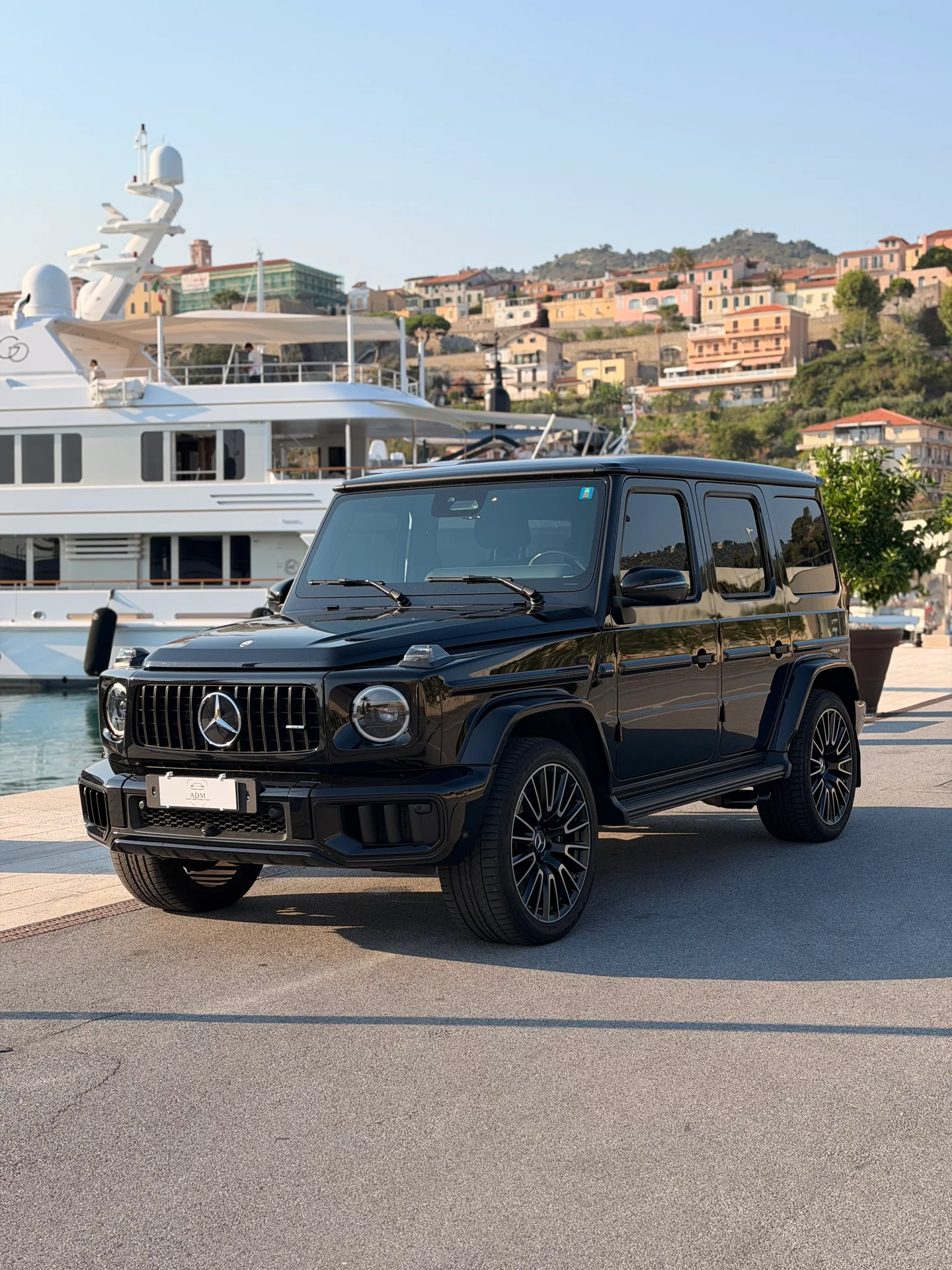 Black Mercedes-AMG G63 seen from the front three-quarter angle beside yachts